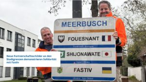 Foto-Info: Am Büdericher Ortseingang Niederlöricker Straße hängte Bürgermeister Christian Bommers gemeinsam mit Bauhof-Mitarbeiter Mathias Frenken das erste neue Partnerschaftsschild auf. Foto: Stadt Meerbusch