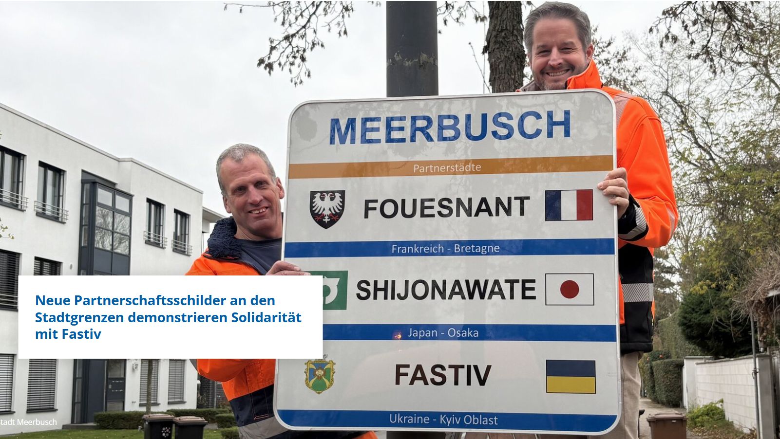 Foto-Info: Am Büdericher Ortseingang Niederlöricker Straße hängte Bürgermeister Christian Bommers gemeinsam mit Bauhof-Mitarbeiter Mathias Frenken das erste neue Partnerschaftsschild auf. Foto: Stadt Meerbusch